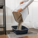 Pouring clay litter into a litter box with the SiftEase, using a litter box sifter makes cleaning easy without the hassle of transitioning to a new litter box.