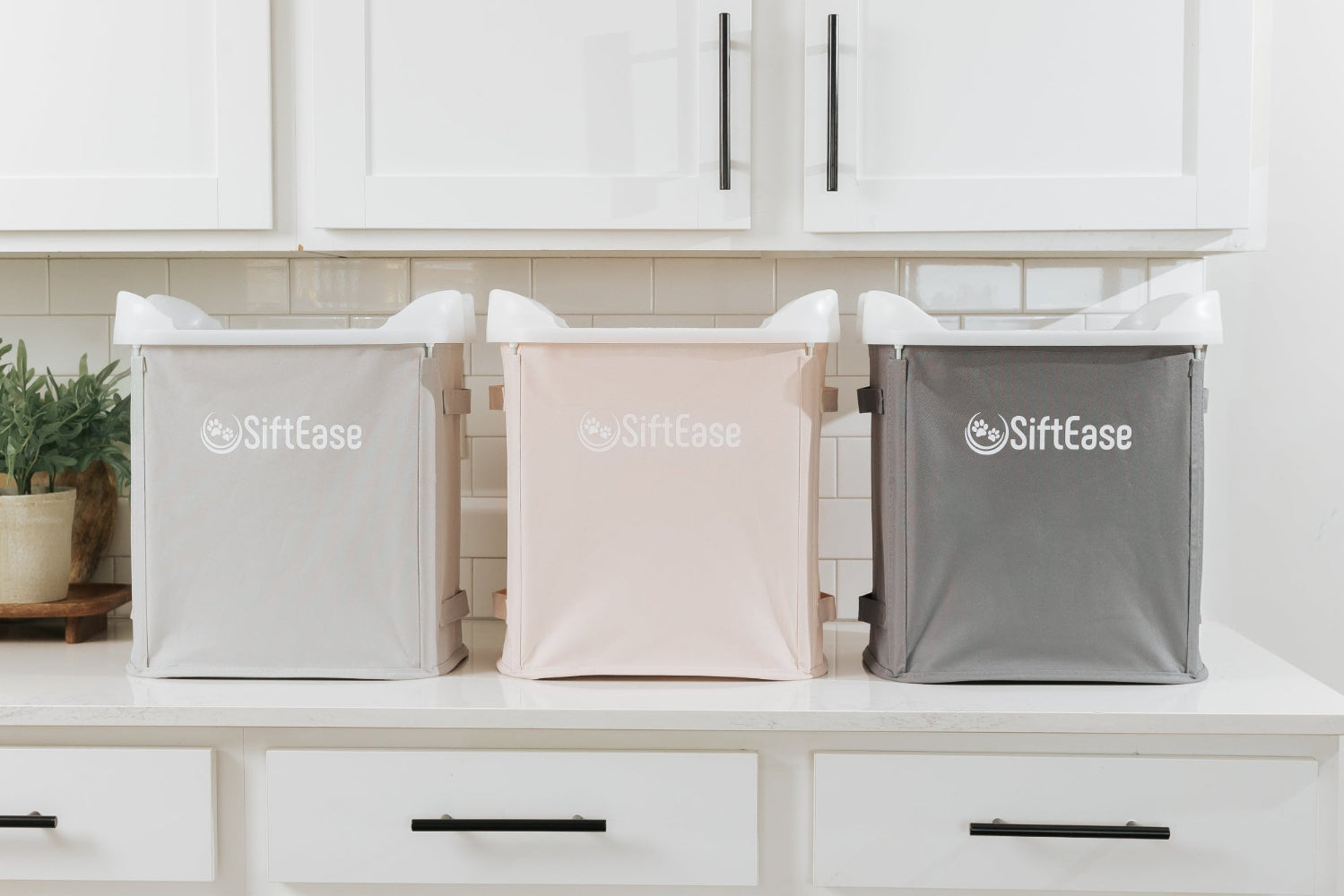 SiftEase litter sifters, sifting litter box cleaners sitting on a counter in grey, pink and dark grey