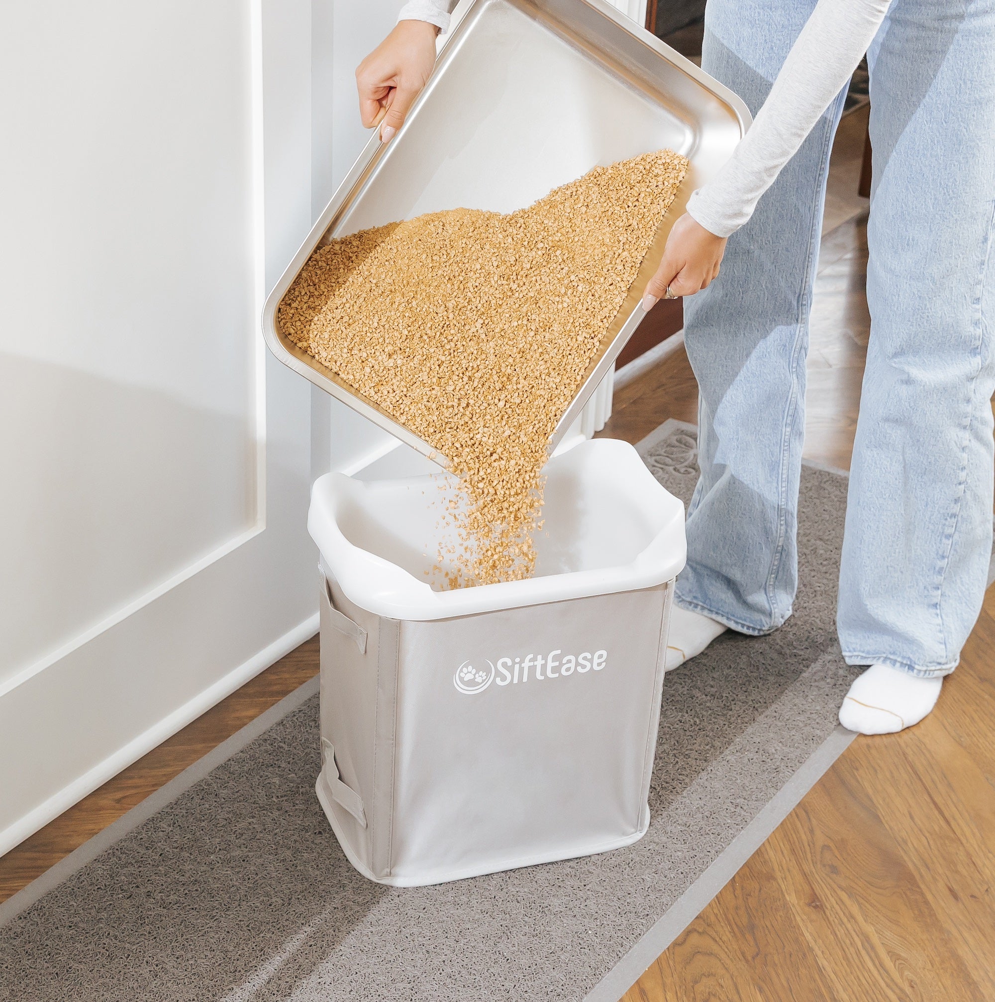 Pouring corn litter from stainless steel litter box showing how SiftEase works with any litter that clumps or can be used with a litter scooper 