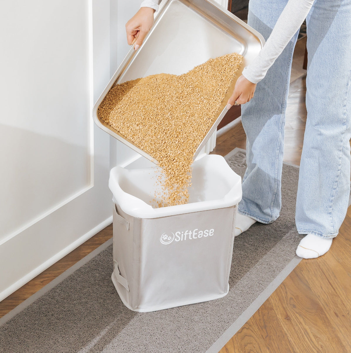 Pouring corn litter from stainless steel litter box, SiftEase works with any litter that clumps or can be used with a litter scooper 